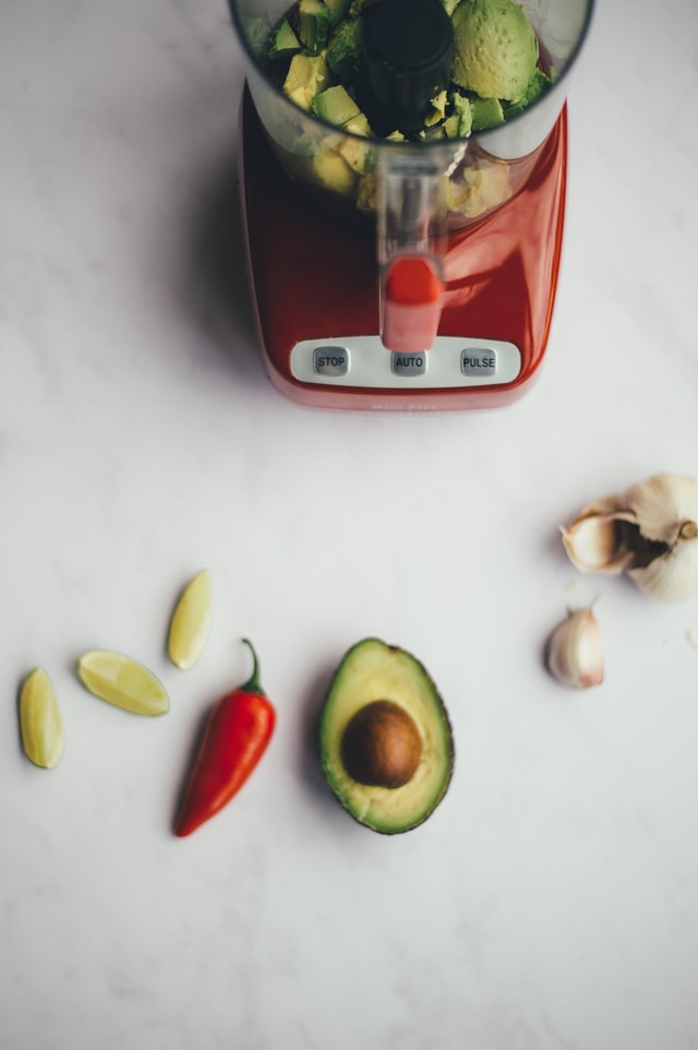 blender with avocado, red pepper, lime and garlic