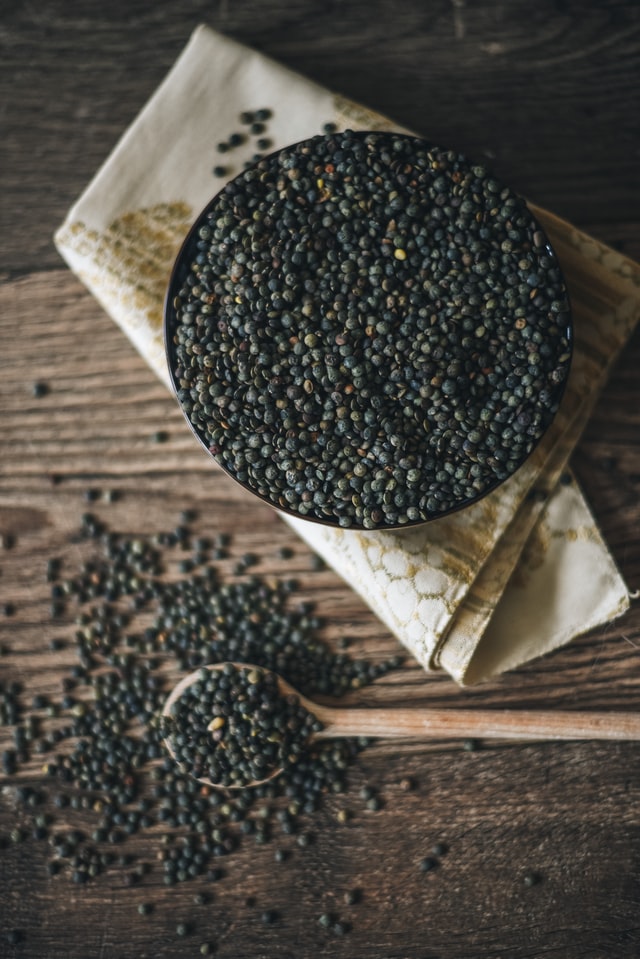 black lentils in bowl and on wooden board