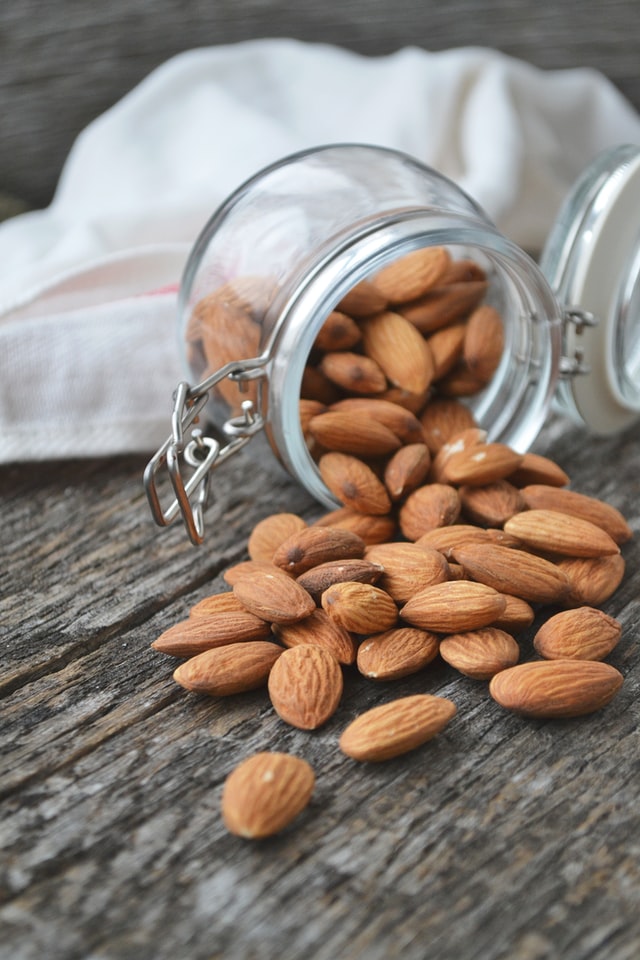 raw almonds spilling from a jar