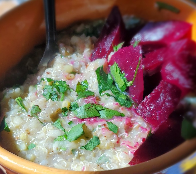 close-up on quinoa bean mixture in orange bow, with chopped parsley and chopped cooked beets