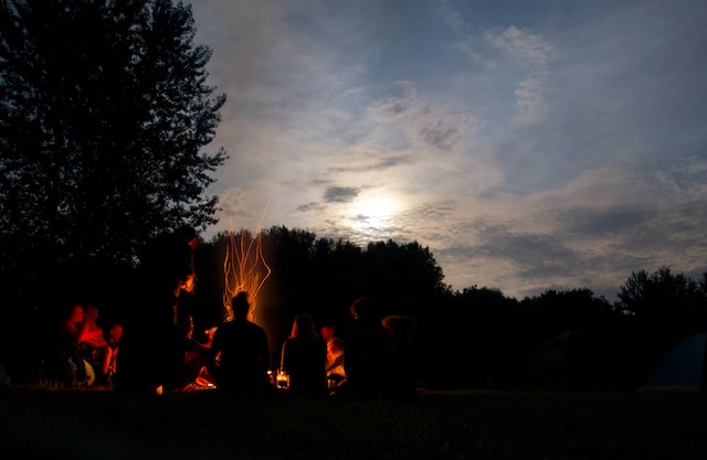 fire ceremony at sunset people sitting in circle around a fire